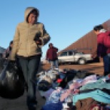 María del Rosario Ceballos, 55, looks through clothes gathered between two security fences at the border during the Christmas at Naco event organized by the Bisbee Rotary Club in collaboration with the local government of Naco, Sonora Wednesday, December 25, 2013, Naco, Ariz.
