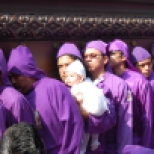 Men, called cucuruchus, dress in purple cloaks, carry a float with the figure of Christ and the cross during the fifth Sunday Lent procession in Antigua, Guatemala. It takes close to 100 men to carry the float that can weigh up to 7,000 pounds. Men generally buy their turn at local church since being a carrier is considered a great honor.