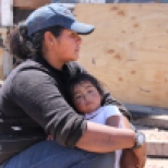 Heidi Sandoval takes a break from sorting plastic and holds her 1-year-old daughter Lizbeth. Heidi lived in a makeshift home by the dump in Nogales, Sonora, but she has now built a home nearby with a help of a U.S. church.