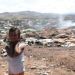 Daniela Sandoval, 5, stands by the remnants of makeshift homes inside el Tirabichi destroyed by a fire. Daniela and her siblings play in the dump while their mother, Heidi, scavenges for recyclables she can sell.